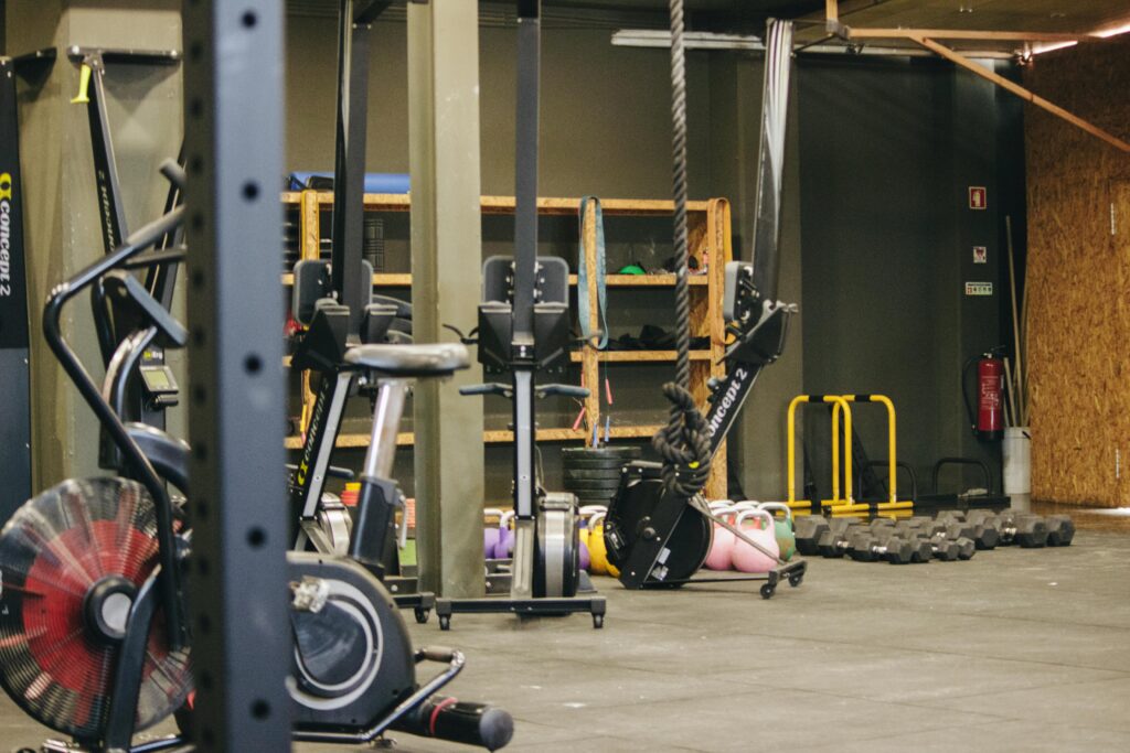 An indoor gym with various exercise equipment and weights ready for workout.